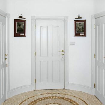 Białe drzwi i złota klamka