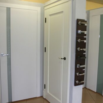 Białe drzwi z przeszklonymi elementami-wystawa